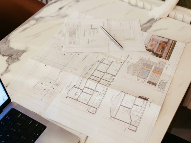 Plans d'architecte et documents de chantier étalés sur une table